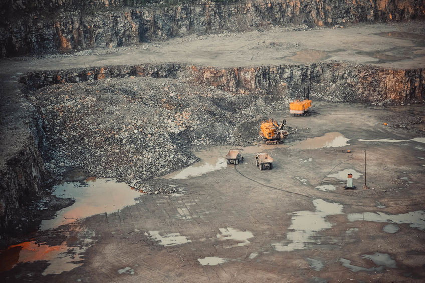 Yellow cars in a large quarry mining granite